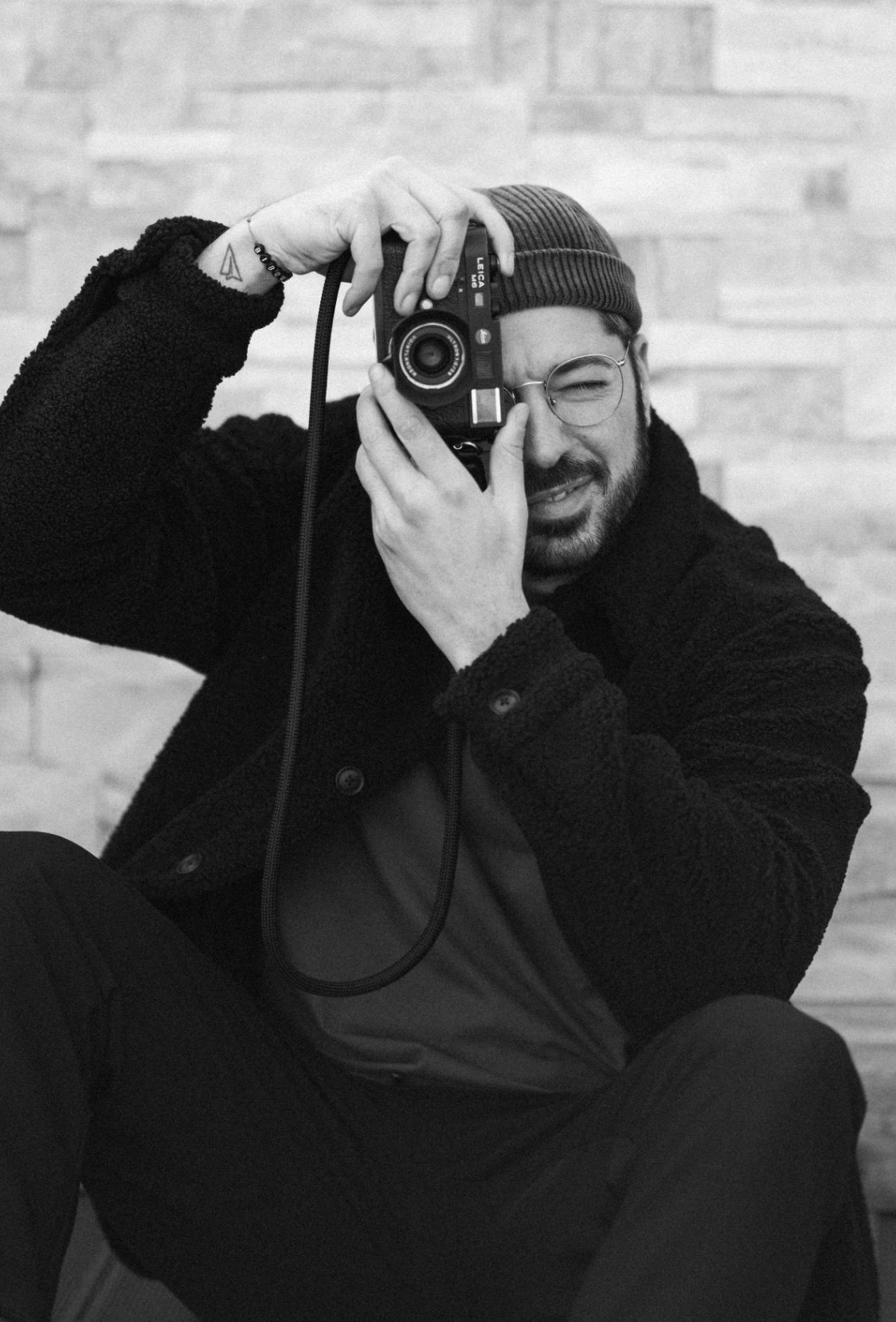 Julien Antunes, appareil photo Leica à l'œil, portrait noir et blanc