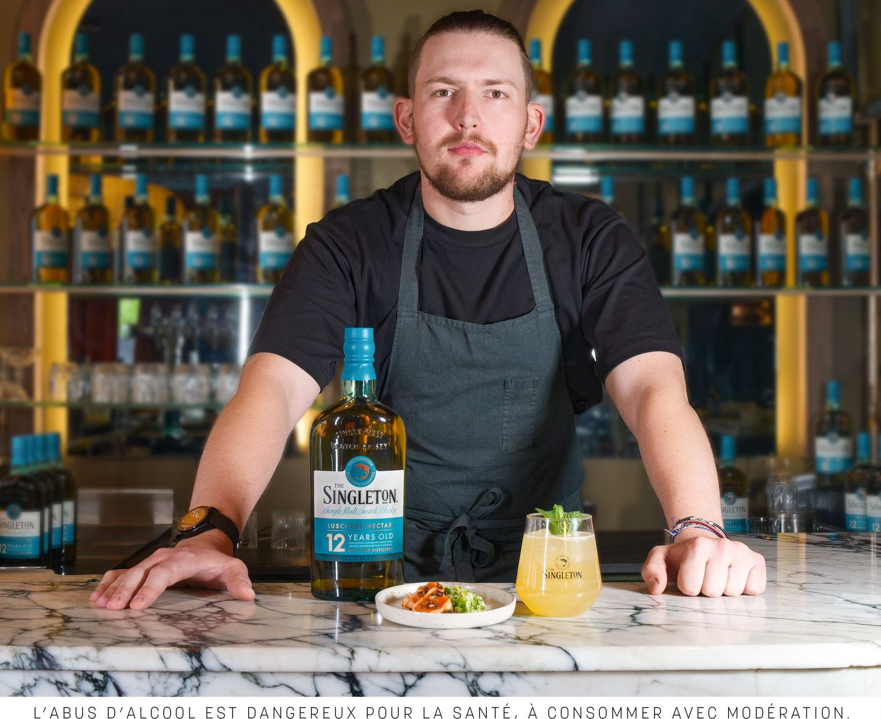 Barman derrière le comptoir avec une bouteille The Singleton