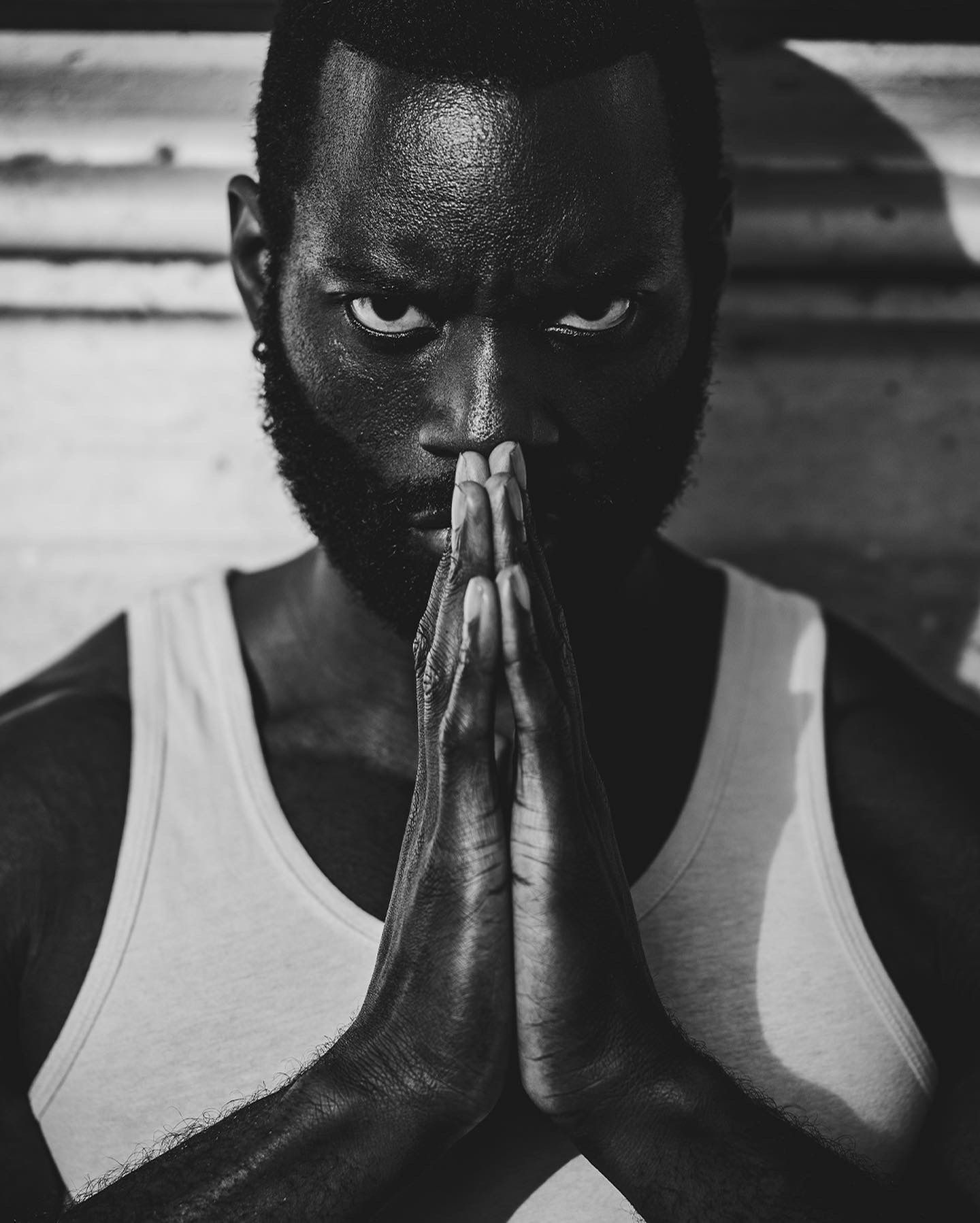 Portrait noir et blanc, mains jointes devant le visage