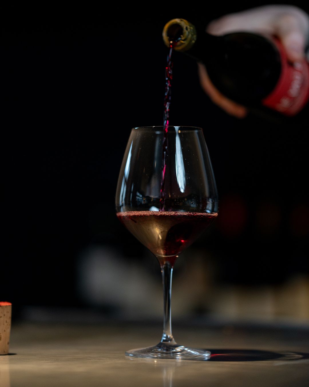 Vin rouge versé dans un verre en clair-obscur